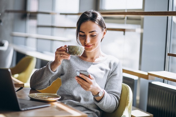 woman-sitting-in-a-cafe-drinking-coffee-and-working-on-a-computer